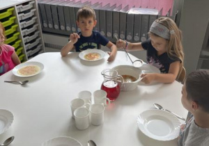 dzieci samodzielnie nalewają zupę z waz